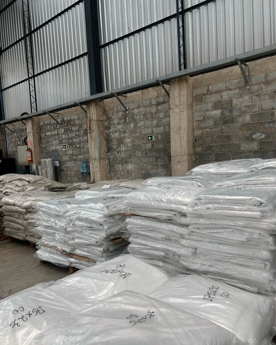 Fardos de embalagens plásticas prontas empilhados no galpão da Plasmundo